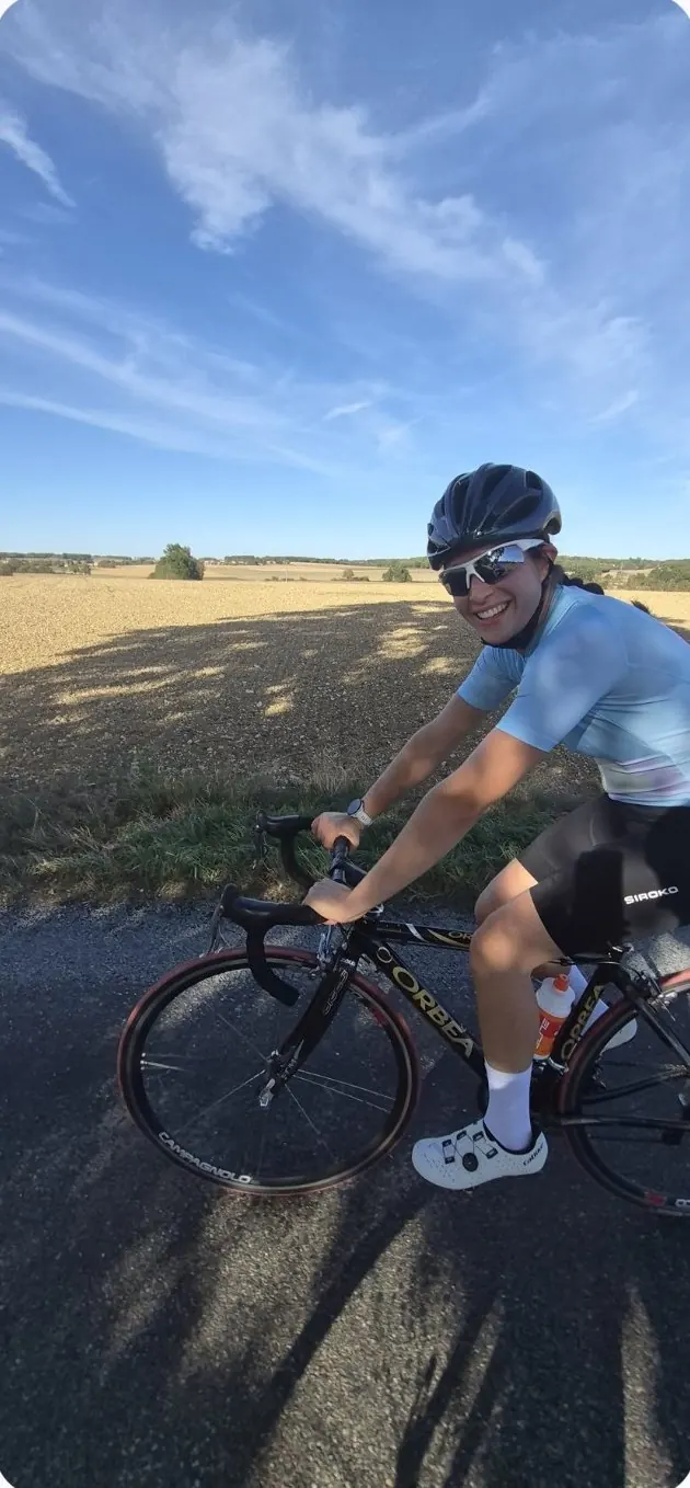 Une adhérente sourit pendant une sortie vélo sur une route de Charente